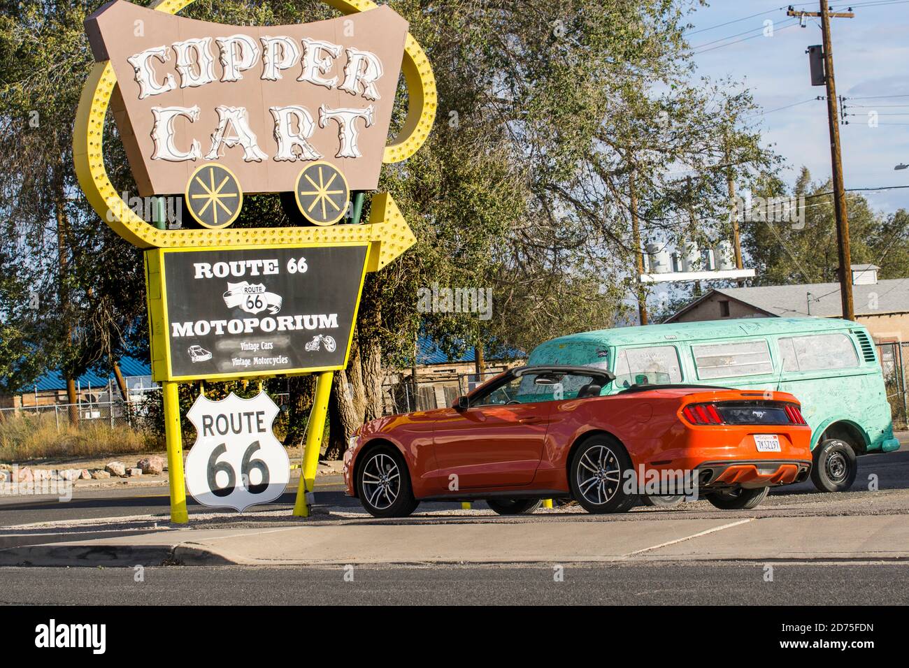 Seligman USA - Settembre 29 2015; tipico stile retrò Route 66 segno per Copper Cart con Mustang moderno parcheggiato sotto e vecchia VW Kombi Foto Stock