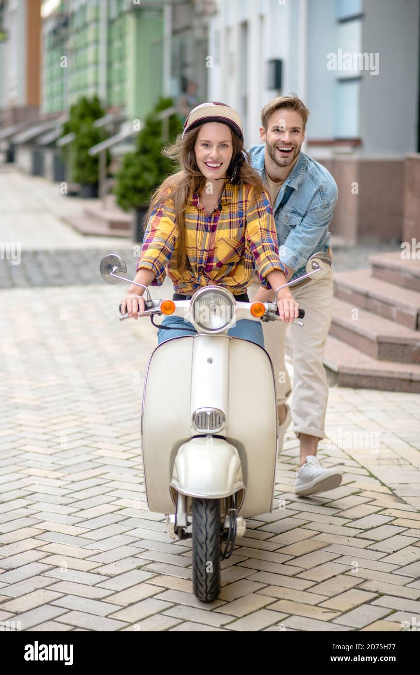 Donna che impara a guidare uno scooter per la prima volta Foto Stock