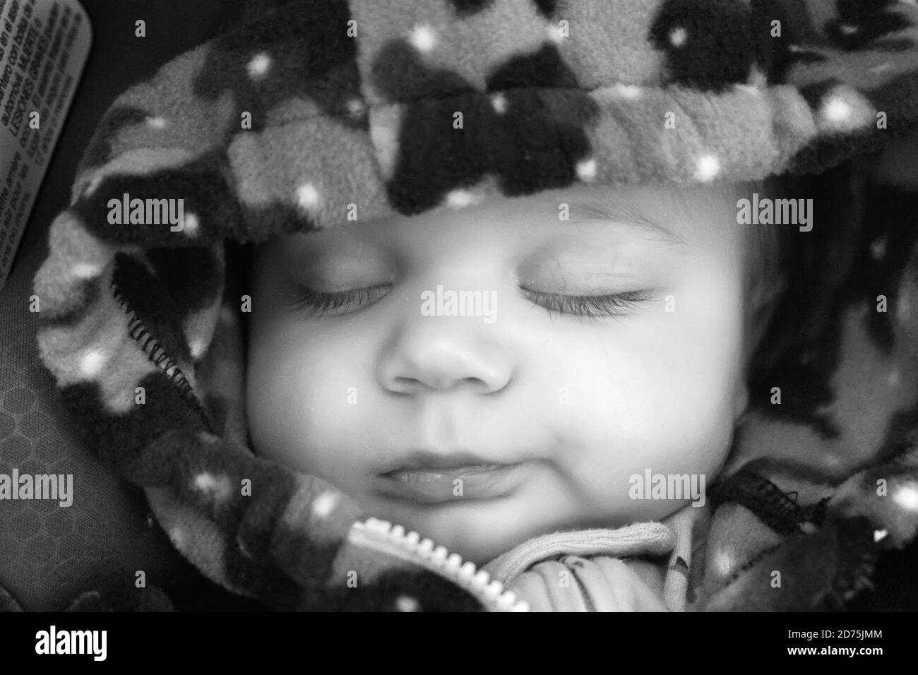Un bambino che dorme indossa un cappuccio Foto Stock