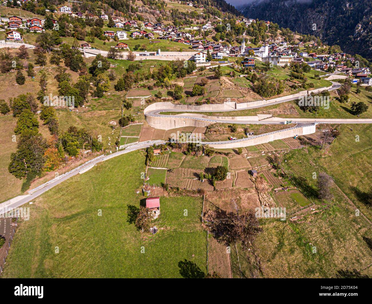 Coltivazione, raccolta e lavorazione dello zafferano a Mund, Naters, Svizzera. Una strada a serpentina si snoda attraverso i vecchi campi di zafferano di Mund nel cantone svizzero del Vallese Foto Stock