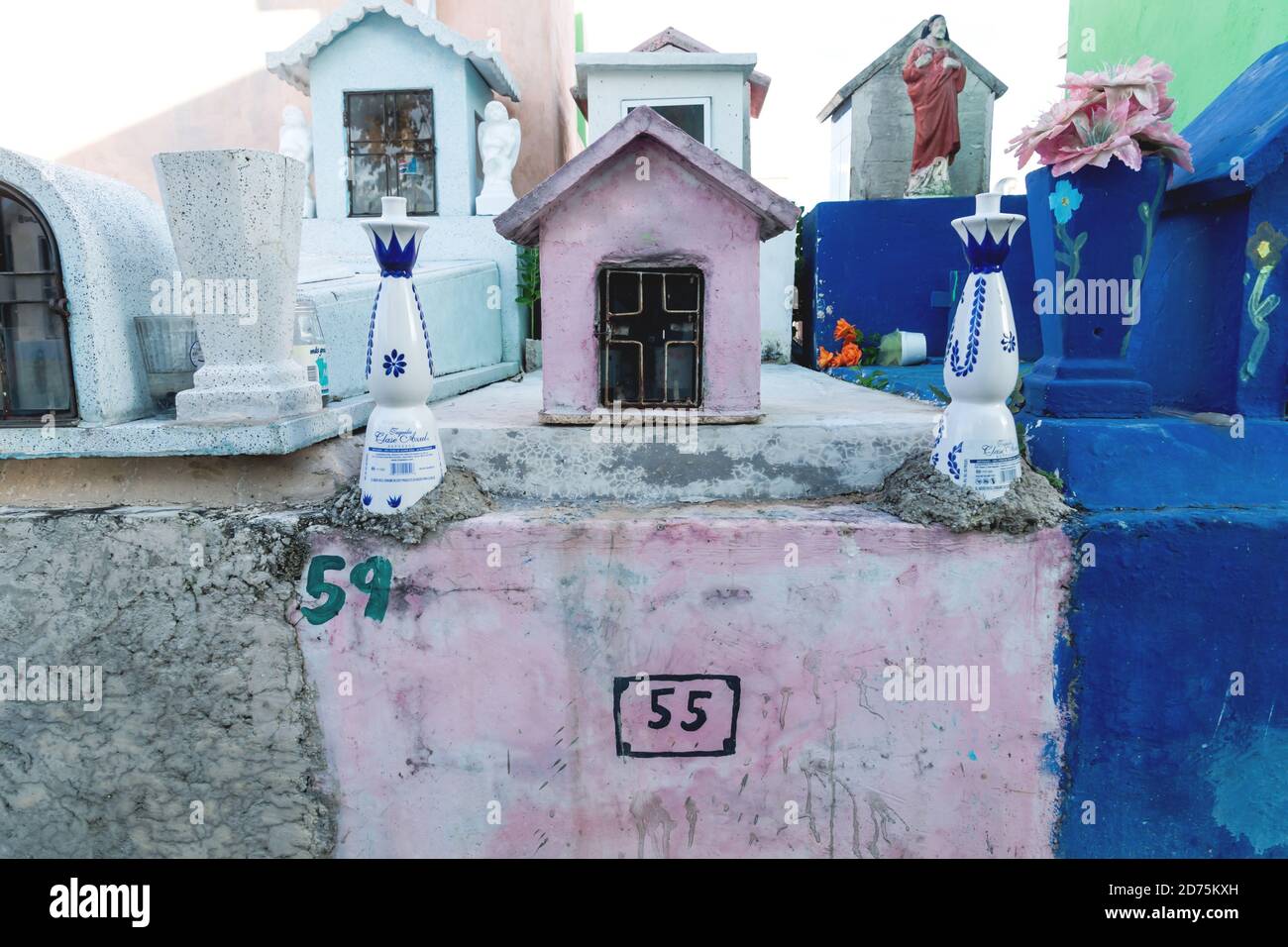 Valladolid, Yucatan, Messico - 29 gennaio 2019: Tipiche tombstones messicane colorate bottiglie di tequilla come decorazione in un cimitero Foto Stock