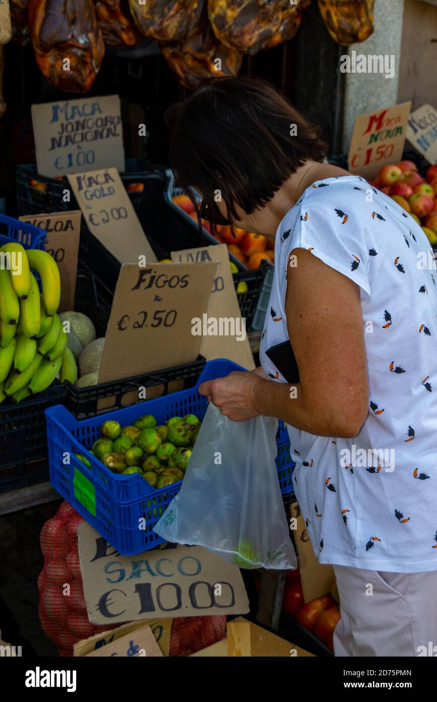 Donna che acquista frutta e verdura al mercato alimentare locale, raccogliendo prodotti locali nel negozio tradizionale locale. Shopping senza maschera. Foto Stock