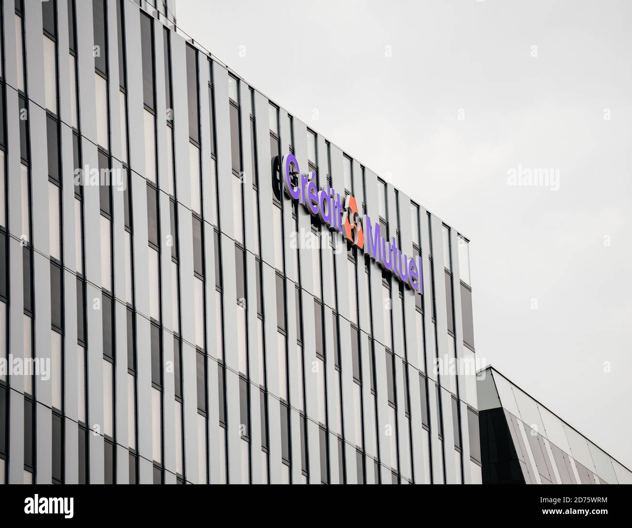 Strasburgo, Francia - 18 ottobre 2020: Logotipo di Credit Mutuel sulla fila di più finestre di uffici e rami di alberi con foglie verdi - concetto di un Plus uffici con basse emissioni di carbonio Foto Stock