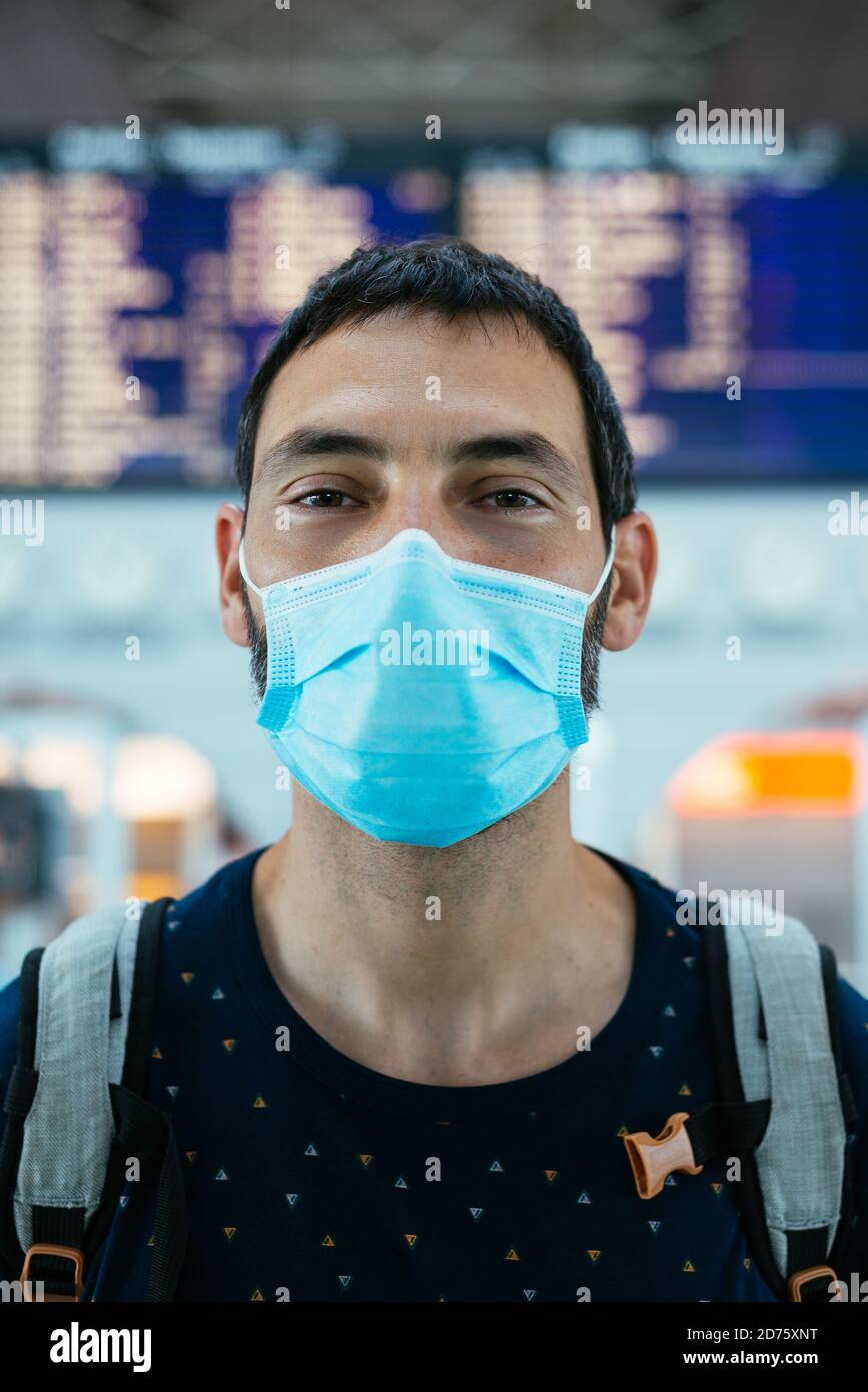 Ritratto di un giovane che indossa una maschera facciale l'aeroporto Foto Stock
