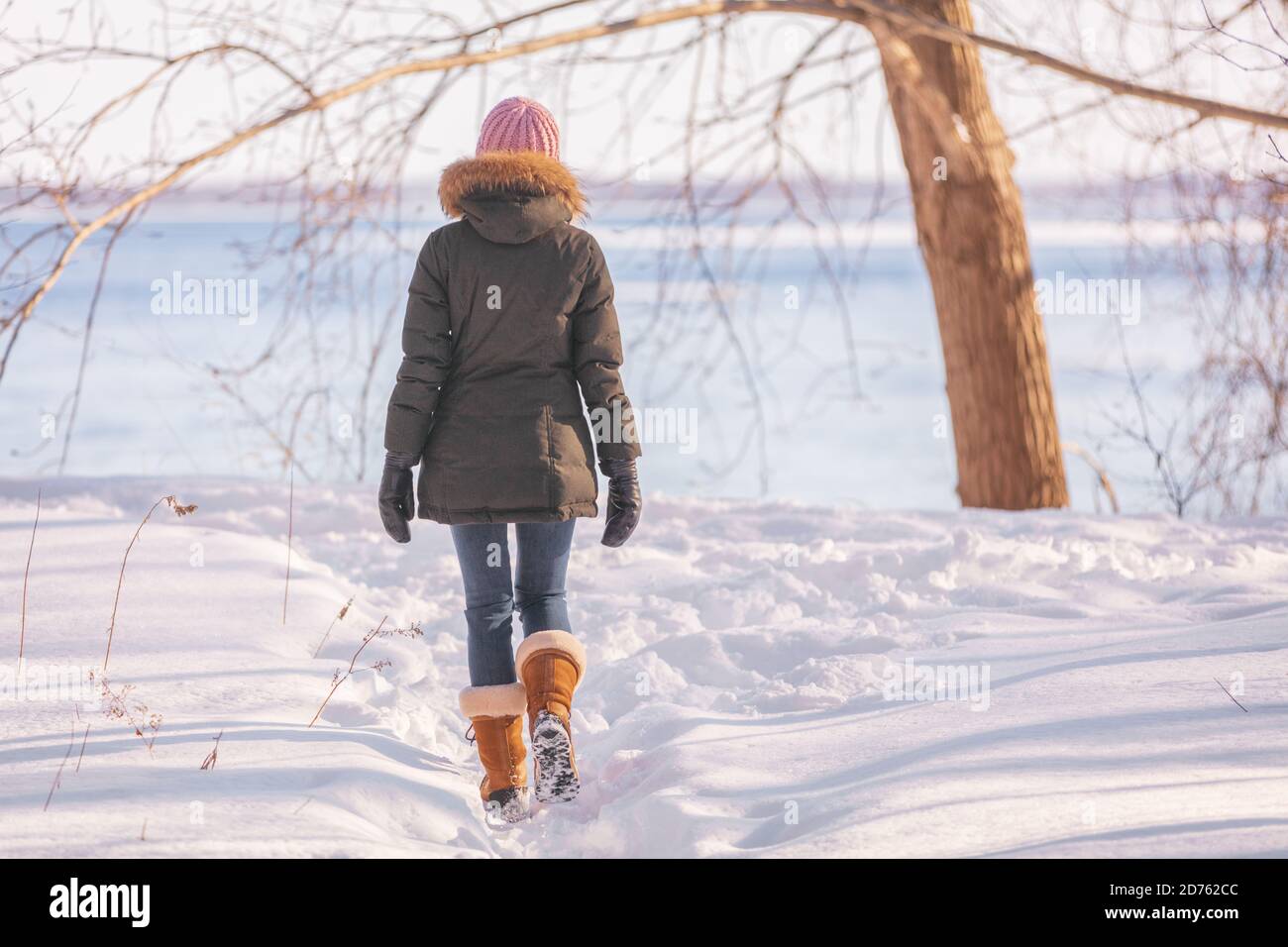 Winter walk donna che cammina sulla natura fiume sfondo in freddo esterno natura fiume esterno indossare cappello di lana, sciarpa e giacca outerwear in pelliccia Foto Stock