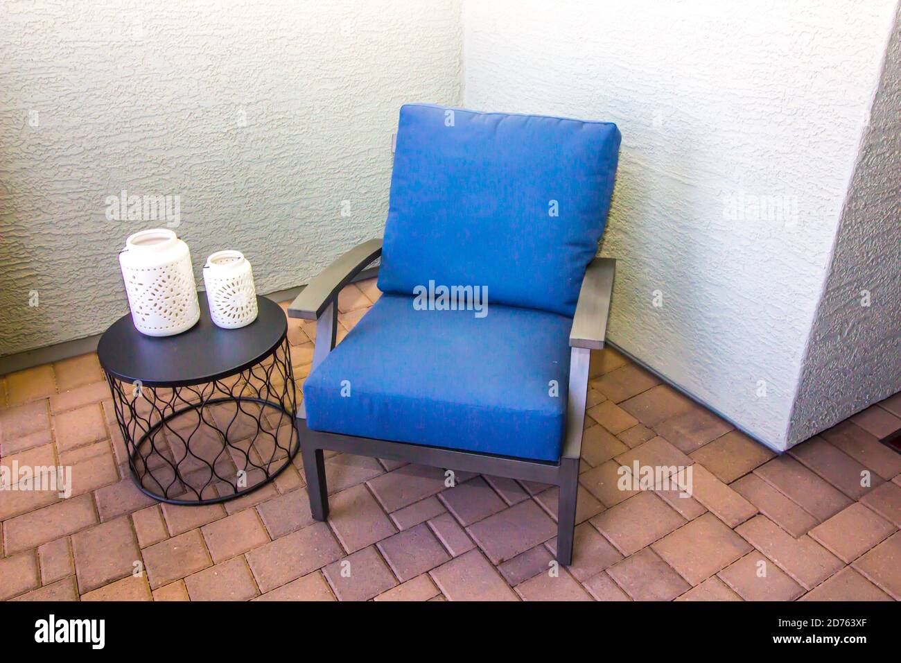 Tavolo rotondo e poltrona patio anteriore con cuscini blu Foto Stock