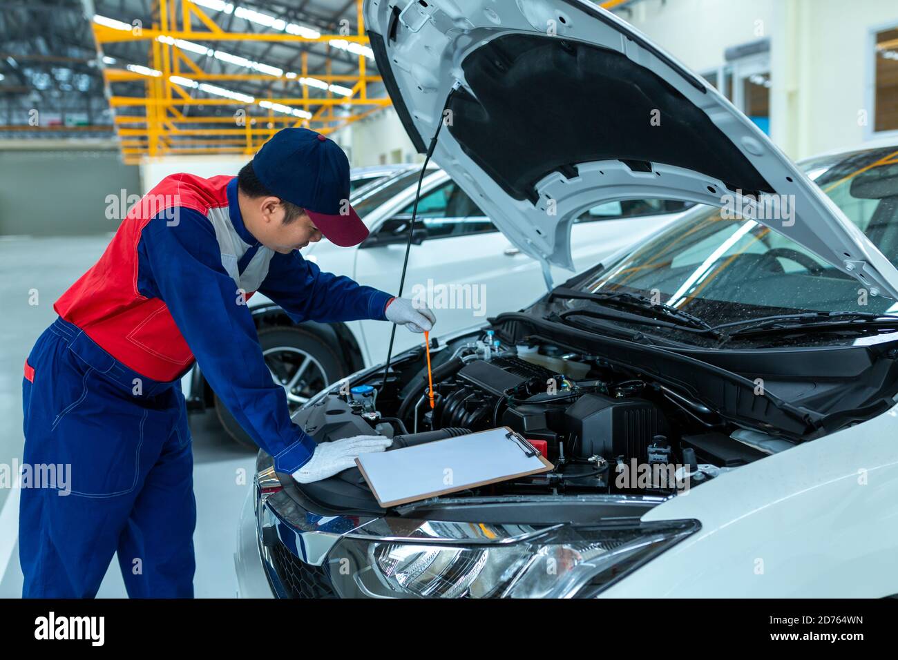 Meccanico automatico controllo olio motore auto nel centro di riparazione auto. Foto Stock