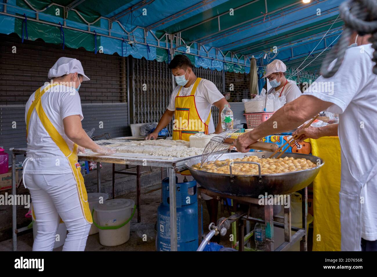 Panettiere preparazione di palle di pane zuccherate fritte popolari come spuntino Un complemento per il caffe' alimentare in un mercato alimentare di strada in Thailandia Foto Stock