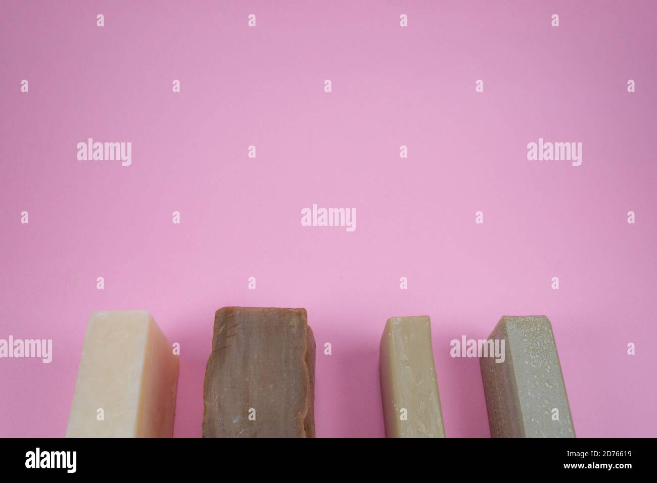 Cinque saponi di colore diverso sulla composizione di sfondo rosa. Foto Stock