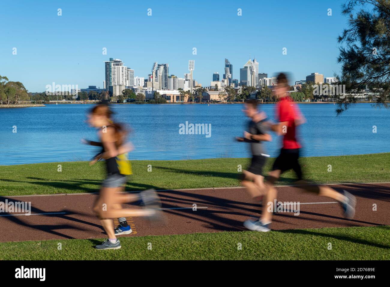 Joggers con Swan River e Perth CBD in background. Foto Stock