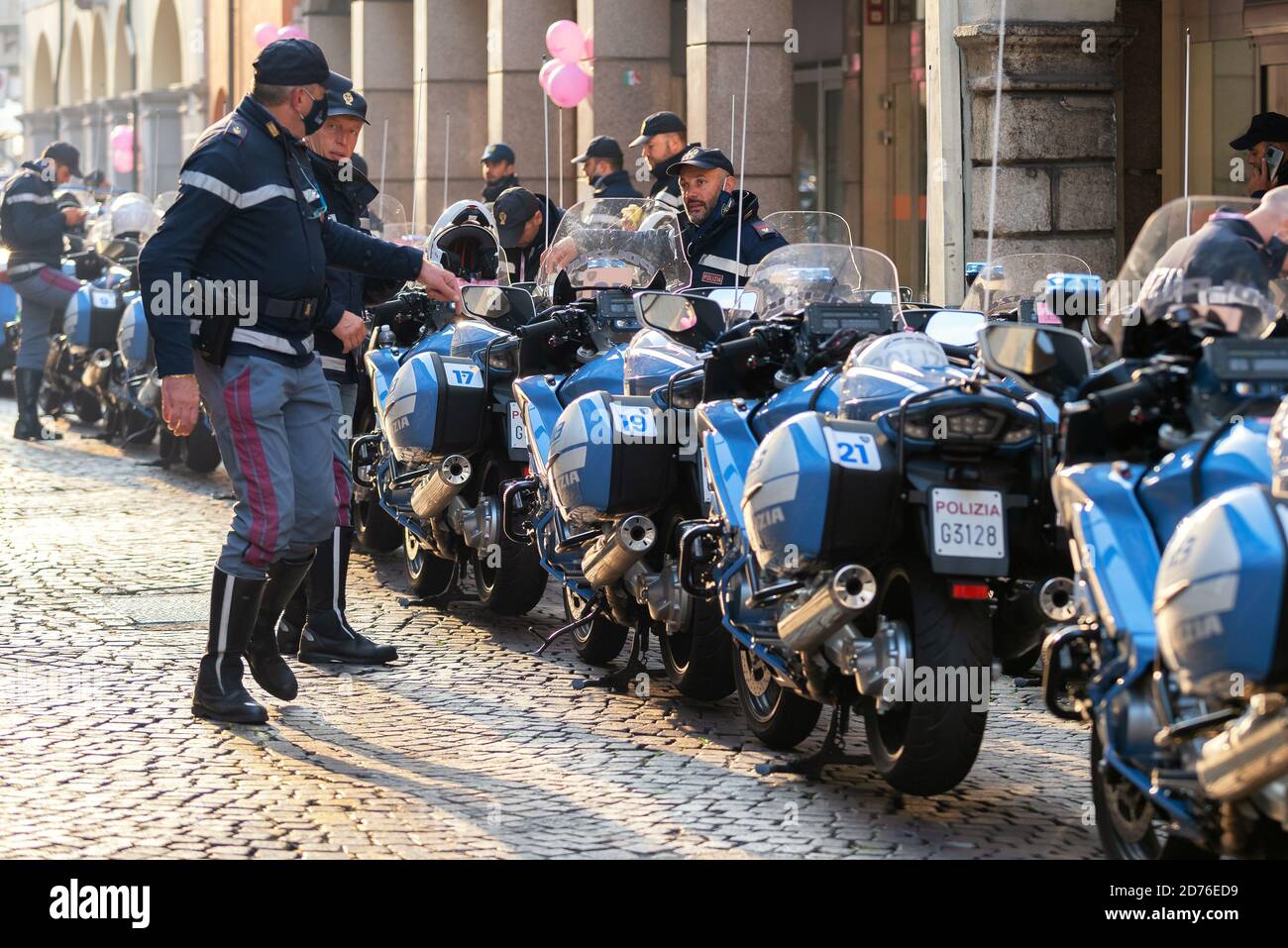 Gruppo di motociclette e poliziotti italiani in una strada acciottolata. Udine, Italia. Foto Stock