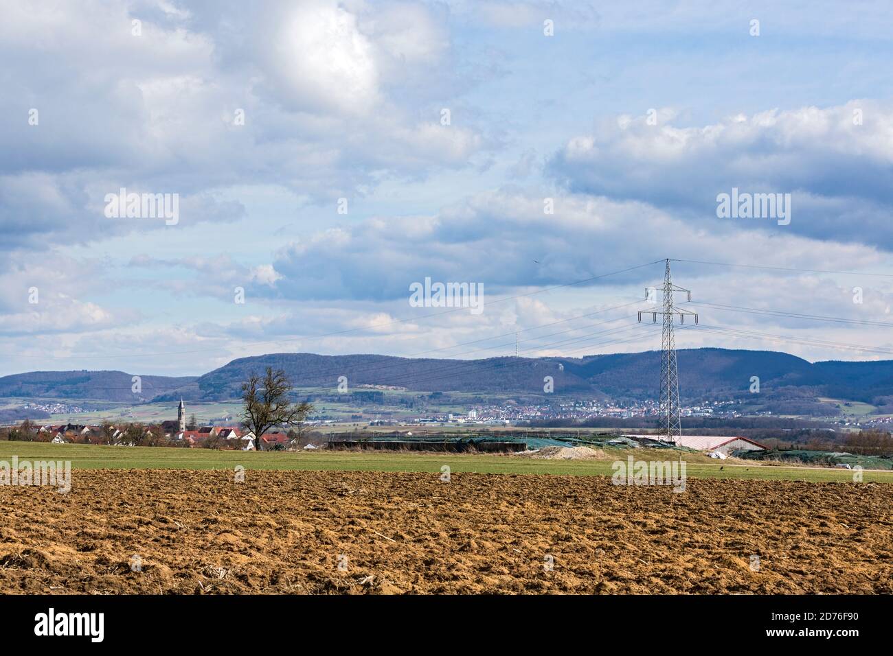 Feld; Acker; Agrarlandschaft; Bauernhof; Ortschaft, Huegel, Stromtrasse Foto Stock