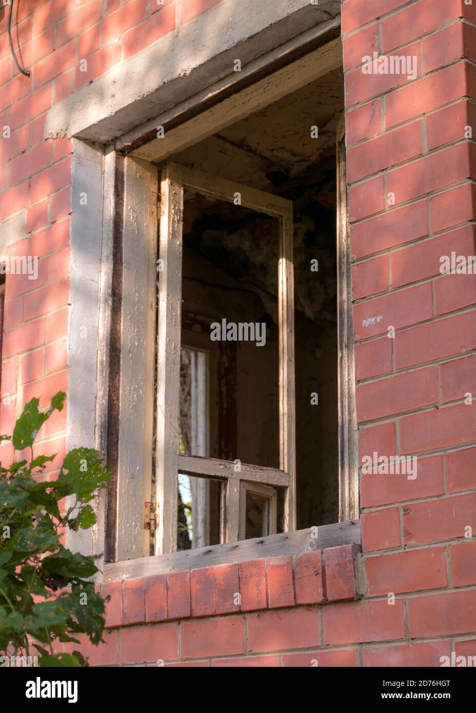 immagine con una vecchia casa di mattoni rossi, finestre senza vetro Foto Stock
