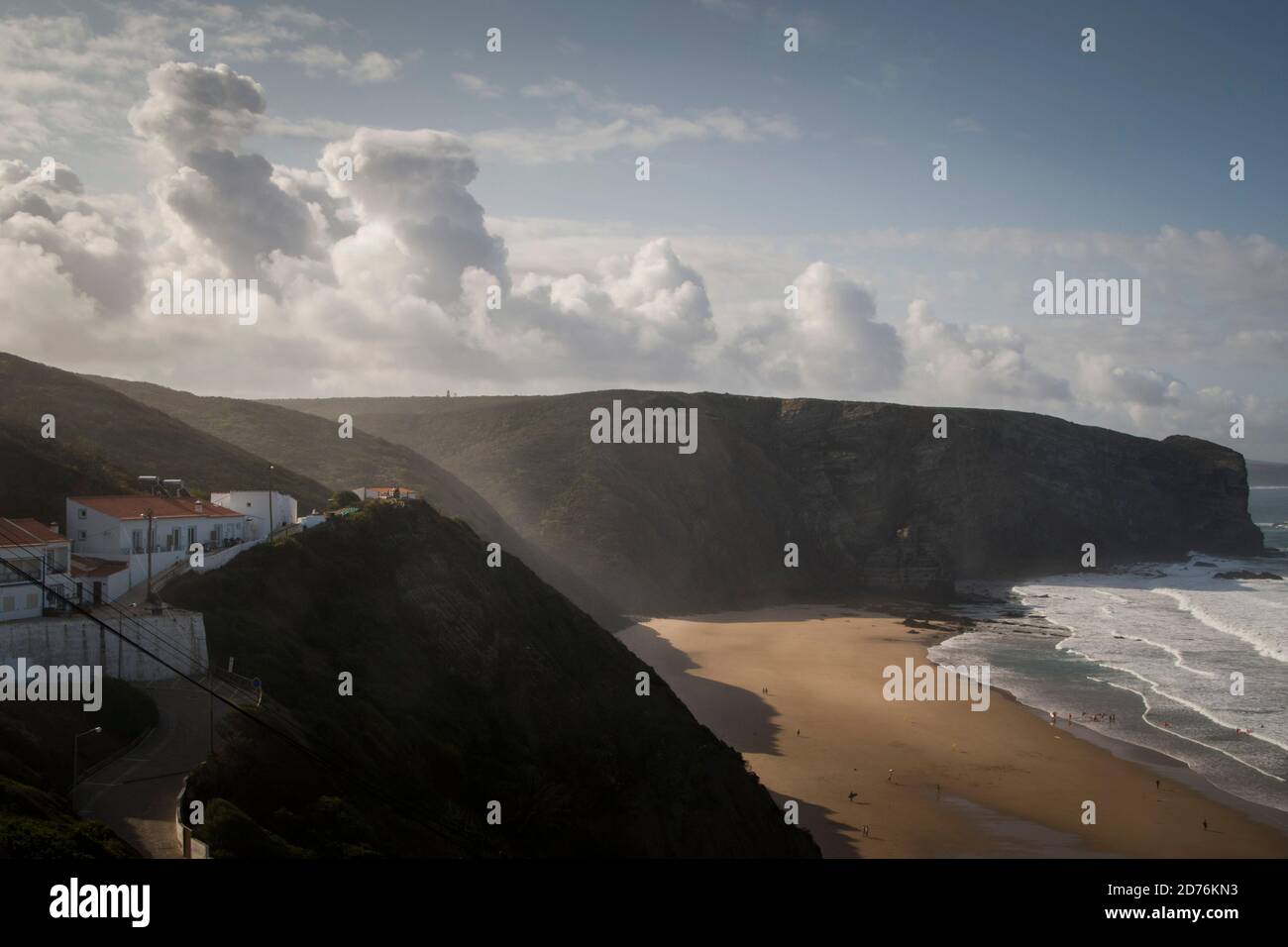 Soffusa luce mattutina che passa attraverso le scogliere in una spiaggia paesaggio sotto le nuvole Foto Stock