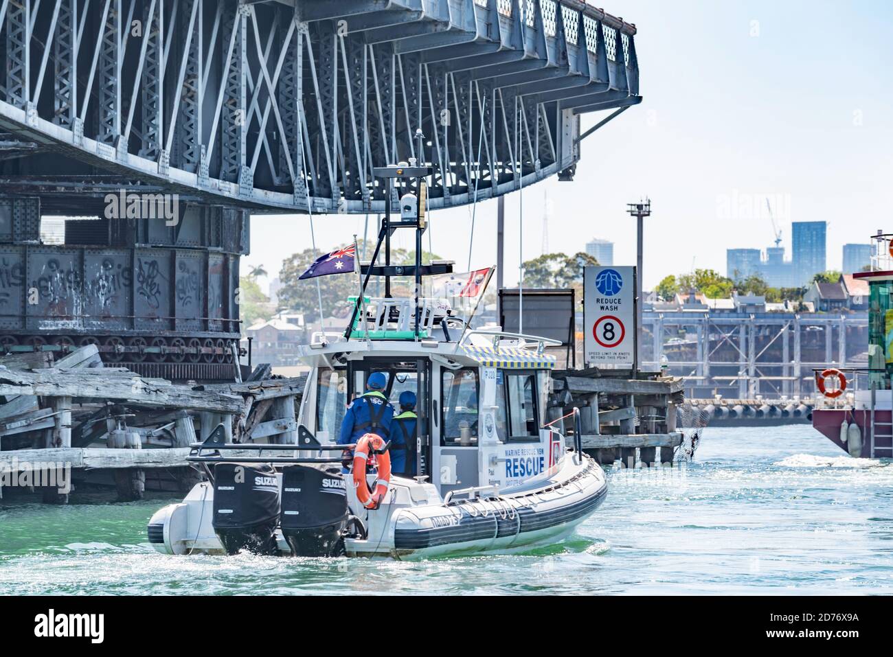 Una barca di soccorso marittima di volontariato viaggia accanto allo storico ponte sospeso 1903 dell'isola di Glebe nel porto di Sydney, Australia Foto Stock