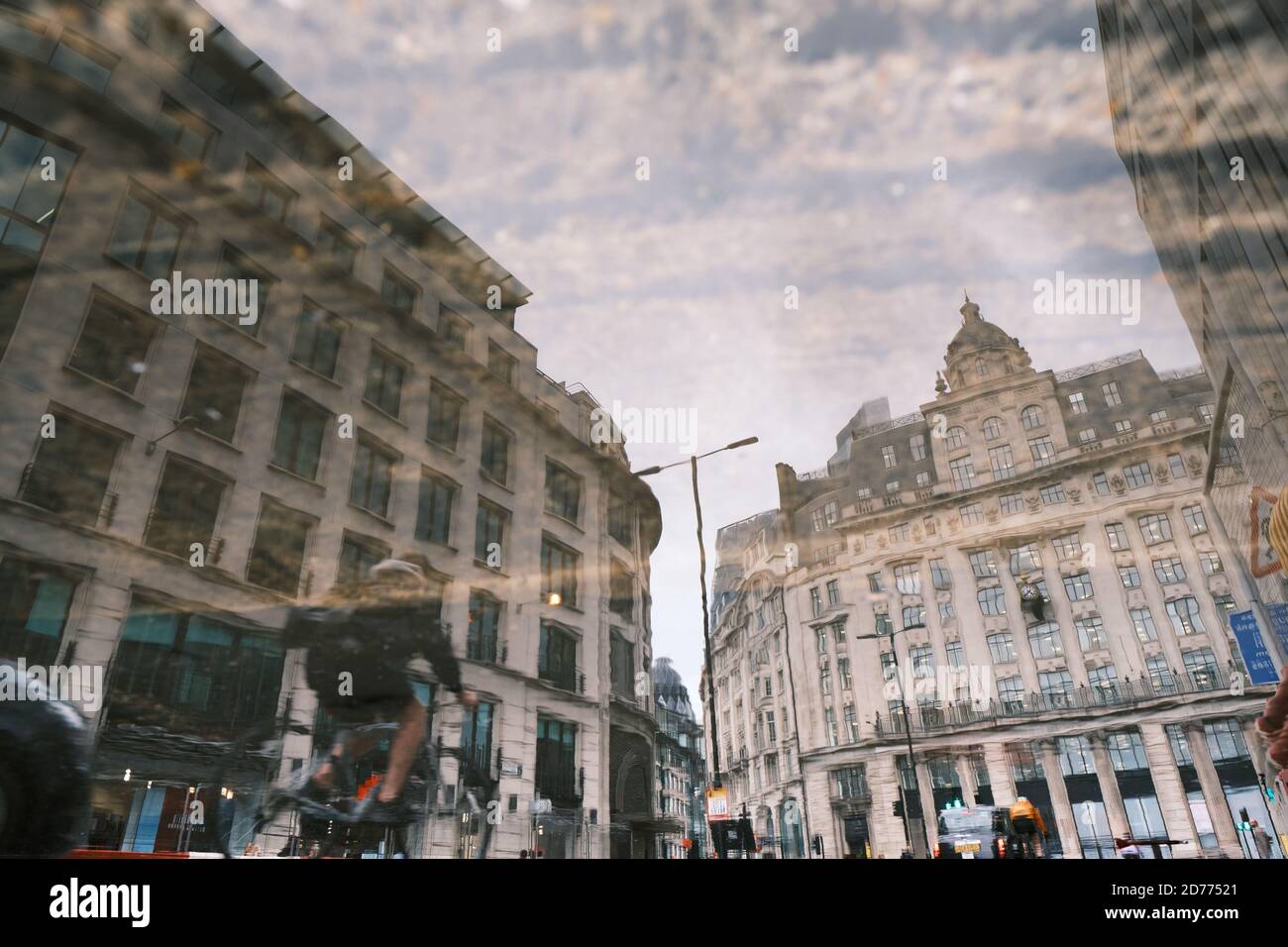 Riflessione degli edifici nel quartiere finanziario di Londra (King William Street, vicino alla stazione della metropolitana Monument) in un pozze. Foto Stock