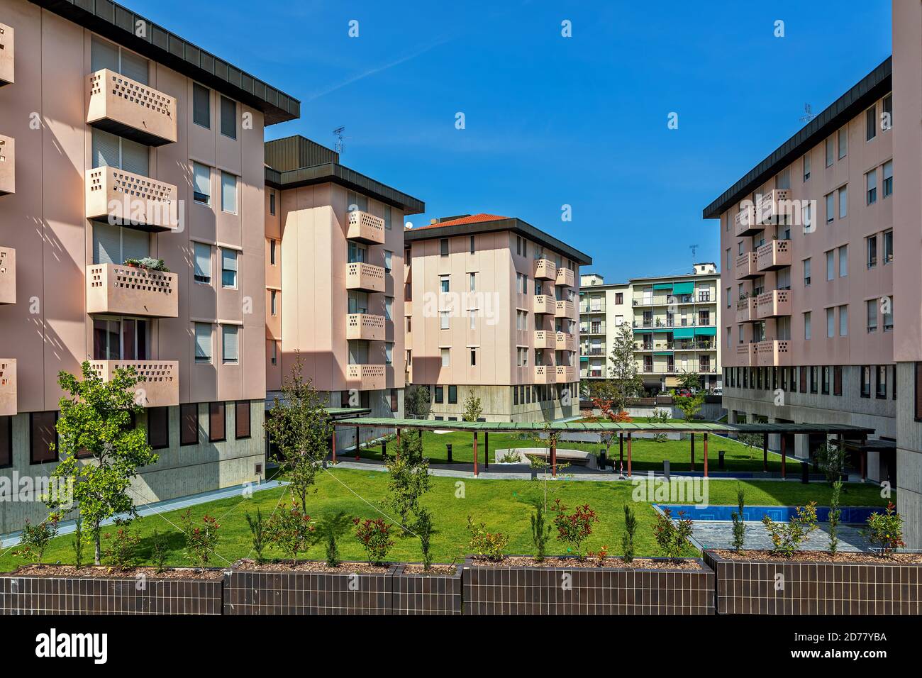 Vista su un complesso di moderni edifici residenziali sotto il cielo blu ad Alba, Piemonte, Italia settentrionale. Foto Stock