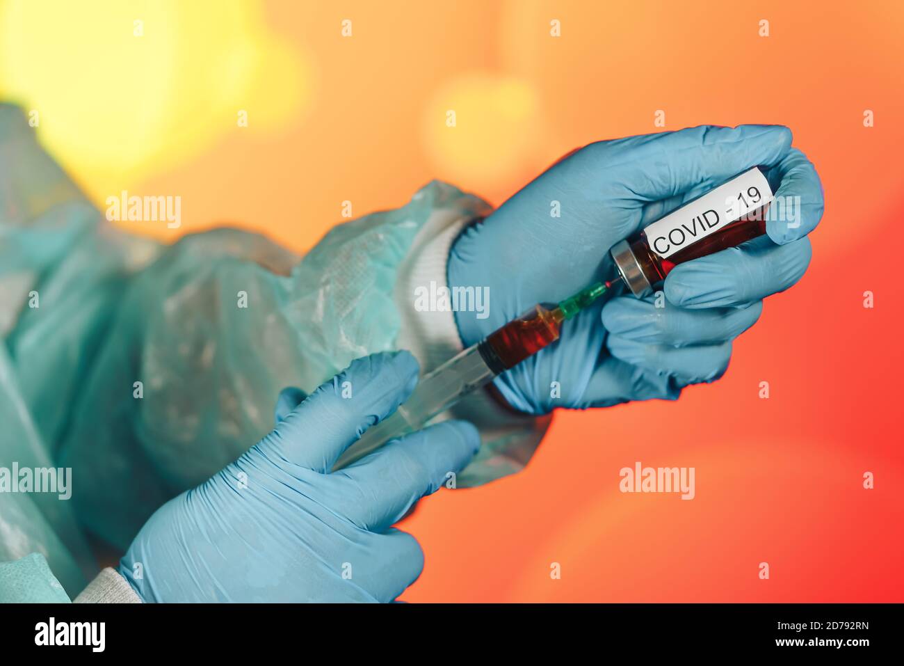 Un medico con guanti blu aspira una fiala in una siringa. Vaccino medico contro il concetto di influenza coronavirus flacone di iniezione per vetro medico Foto Stock