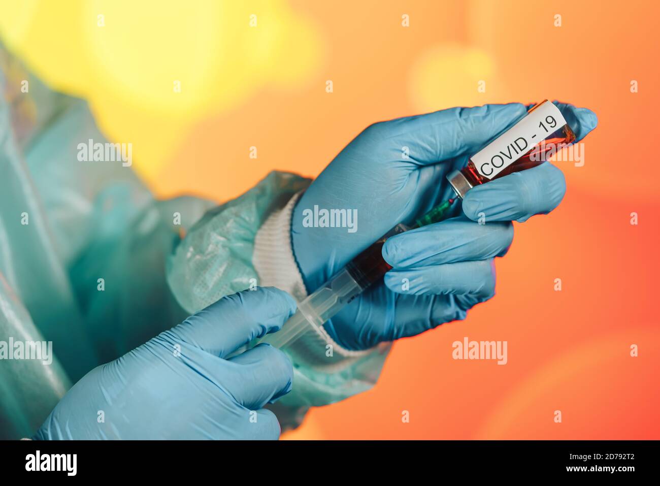 Un medico con guanti blu aspira una fiala in una siringa. Vaccino medico contro il concetto di influenza coronavirus flacone di iniezione per vetro medico Foto Stock