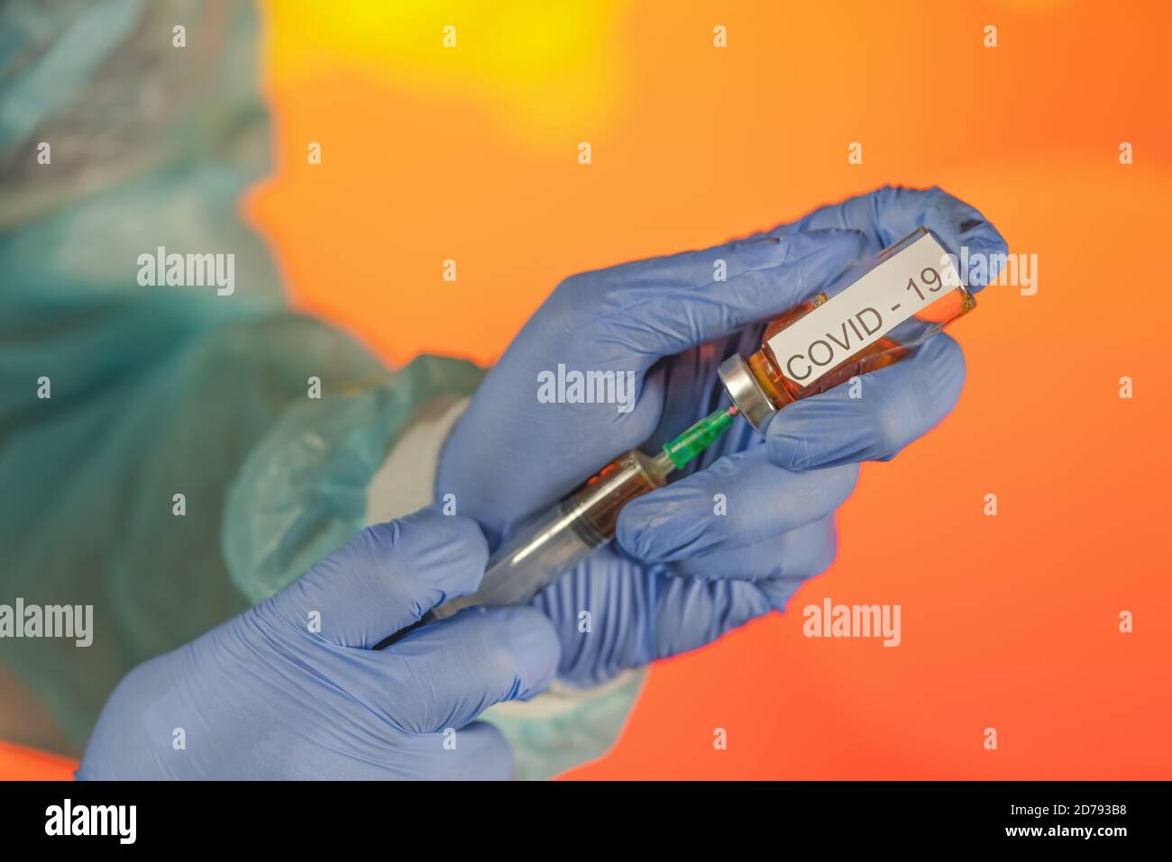 Un medico con guanti blu aspira una fiala in una siringa. Vaccino medico contro il concetto di influenza coronavirus flacone di iniezione per vetro medico Foto Stock