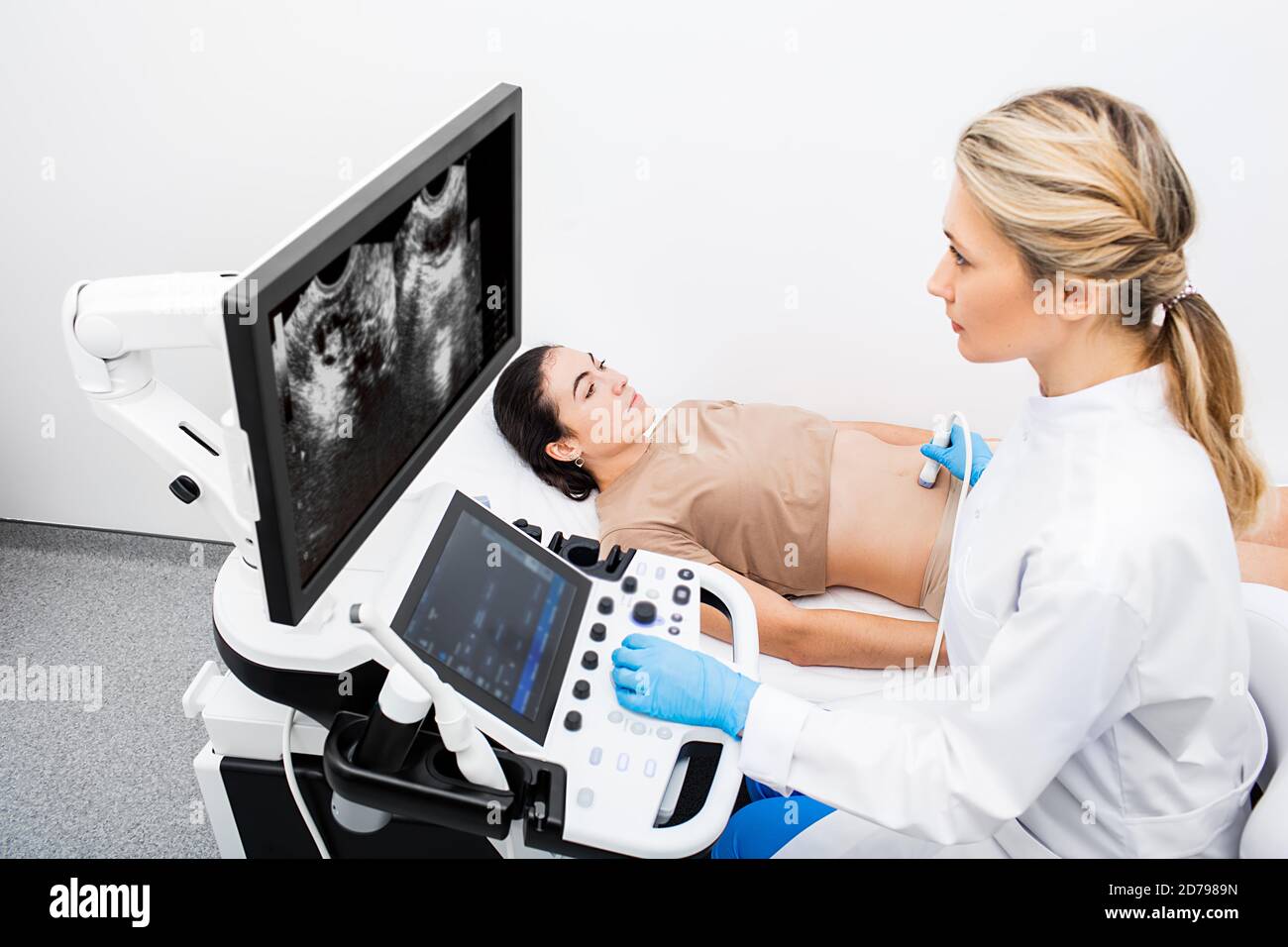 Donna che ha un esame ecografico di utero e ovaie presso l'ufficio ginecologo in una clinica moderna. Salute delle donne Foto Stock