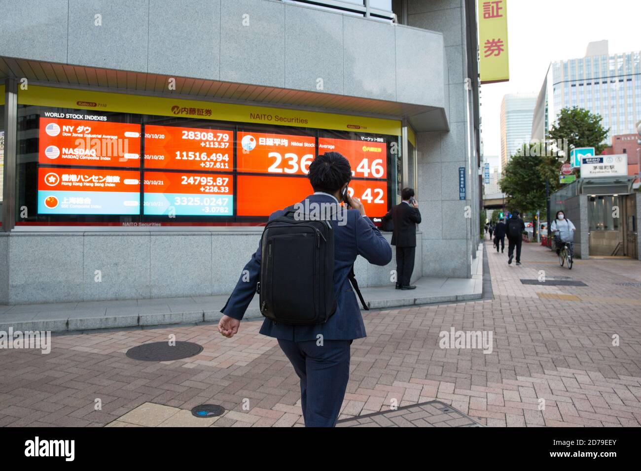 Tokyo, Giappone. 21 Ott 2020. Un uomo che parla al telefono camminando da un bordo elettronico della borsa con i tassi crescenti dei commerci in tempo reale a Tokyo. Credit: Stanislav Kogiku/SOPA Images/ZUMA Wire/Alamy Live News Foto Stock