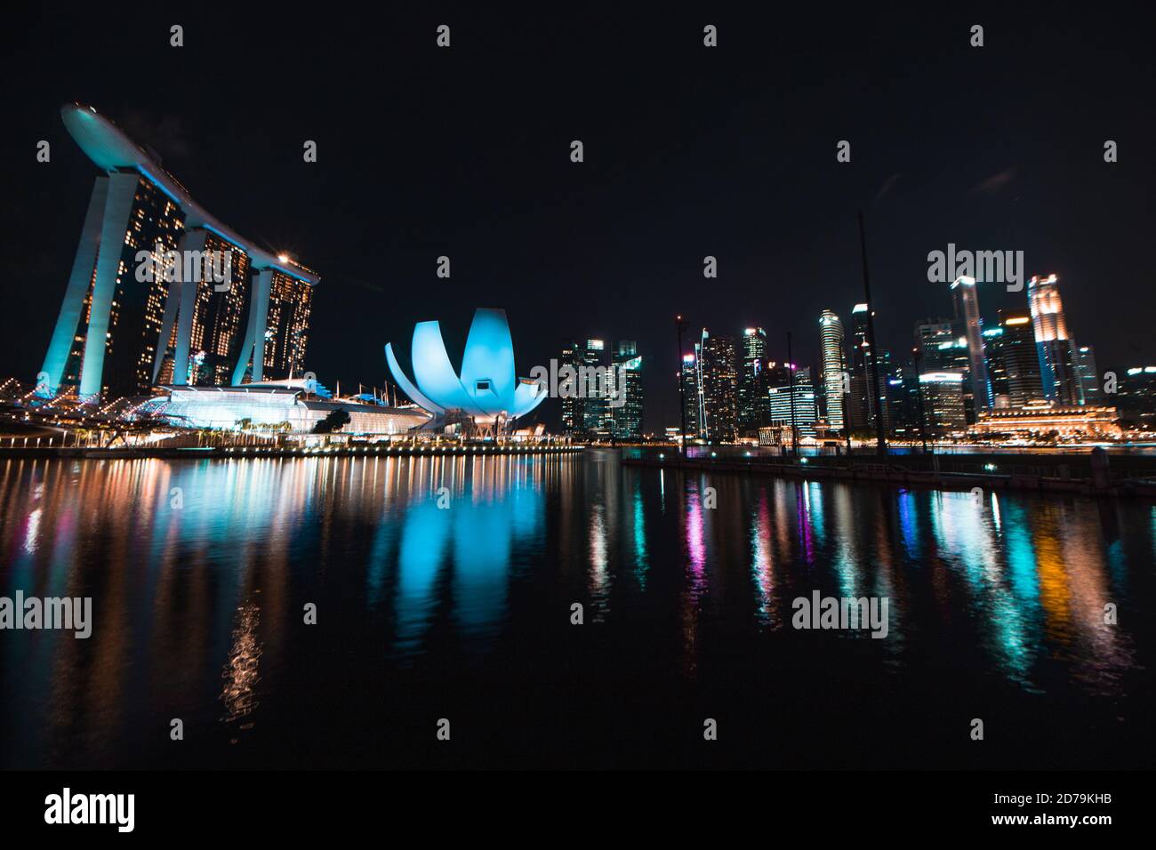 Si tratta di una lunga esposizione del paesaggio notturno cittadino di Singapore che presenta le famose Terre di Marina Bay. La riflessione si può vedere anche nelle acque. Foto Stock
