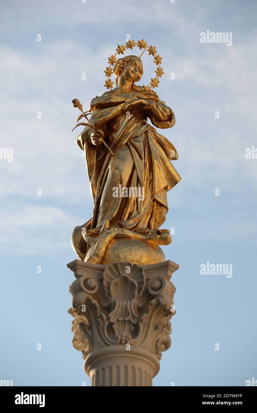 Vergine Maria dorata sulla storica colonna della peste del Piazza principale di Maribor nella Slovenia orientale Foto Stock