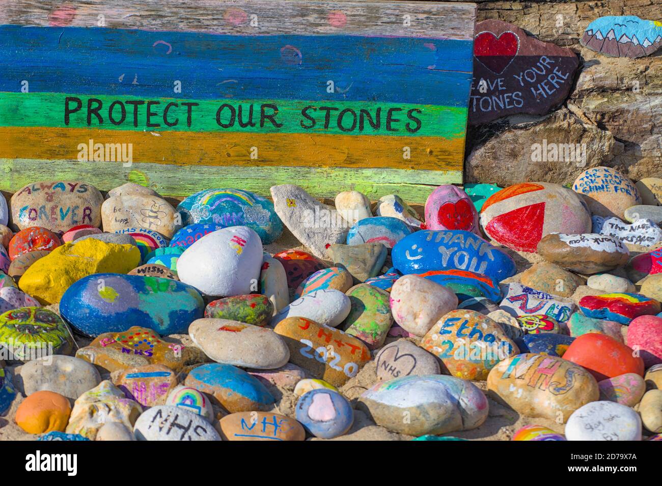 Proteggi il nostro segno di pietre e le pietre colorate dipinte a mano che celebrano The NHS on Avon Beach Christchurch UK Foto Stock