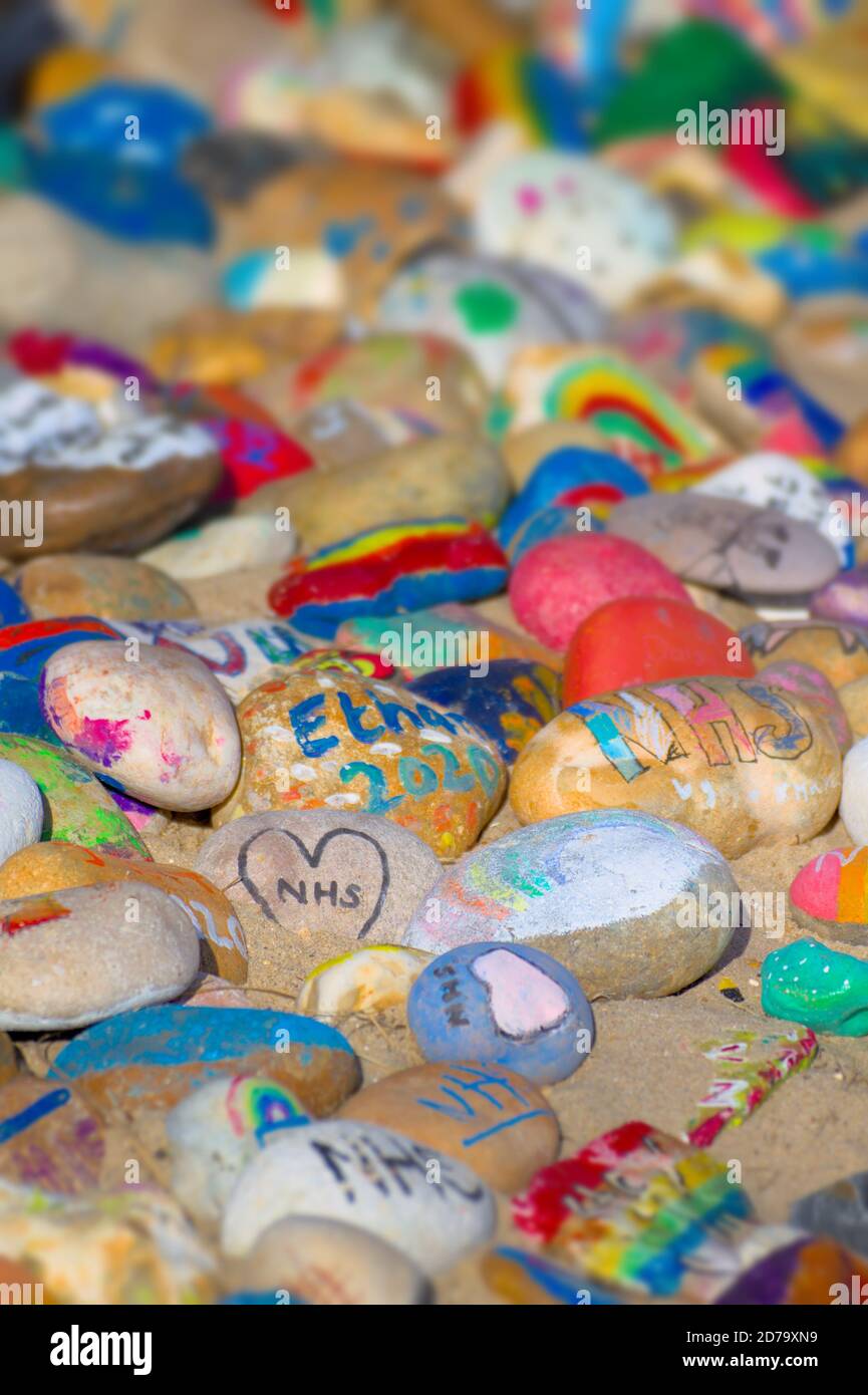 Colorati Pebbles dipinti a mano che celebrano il NHS su Avon Beach Christchurch Regno Unito Foto Stock