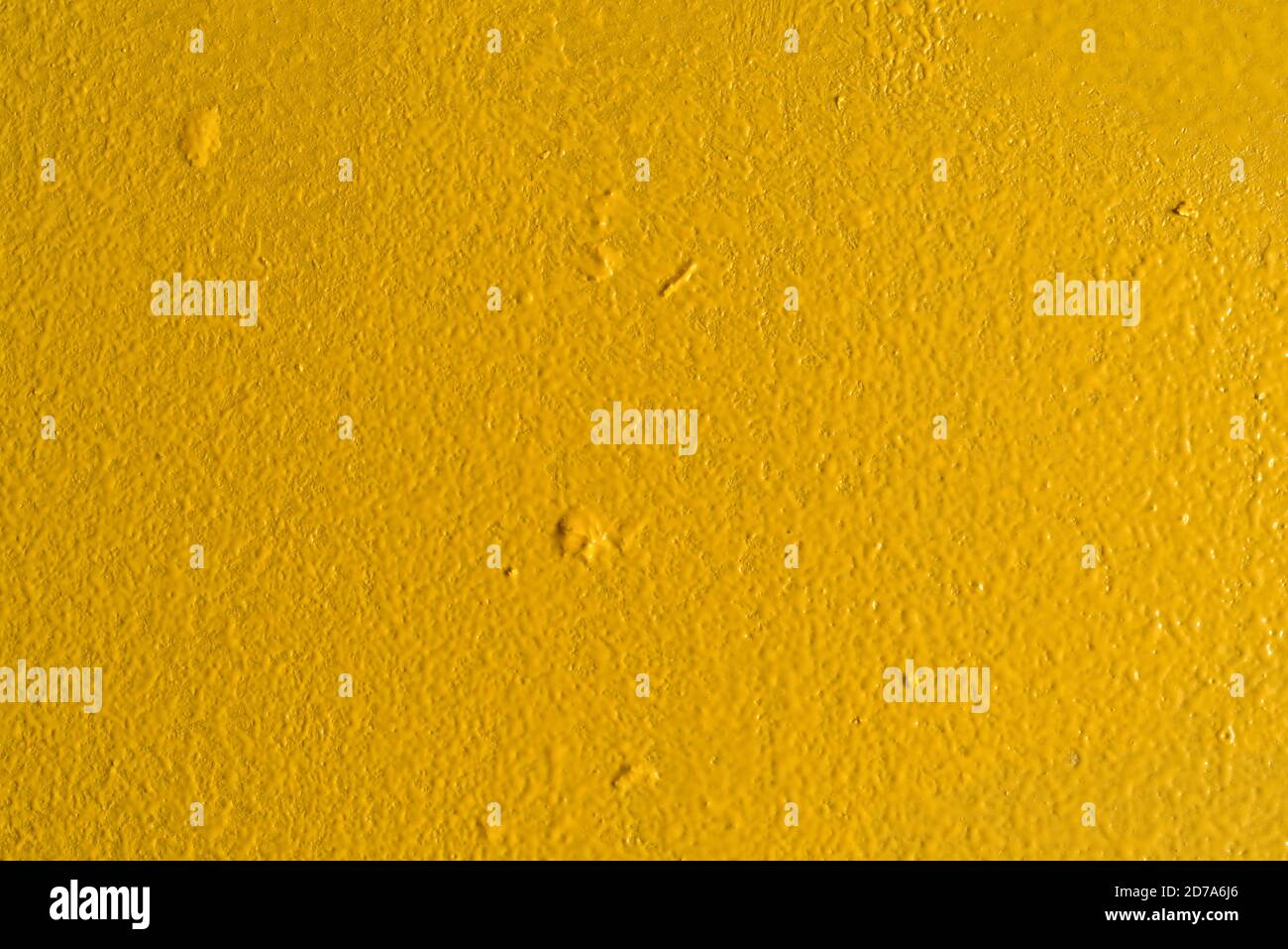 Vista ravvicinata di una parete verniciata di giallo con globi sparsi da un rullo di vernice sporco. Foto Stock