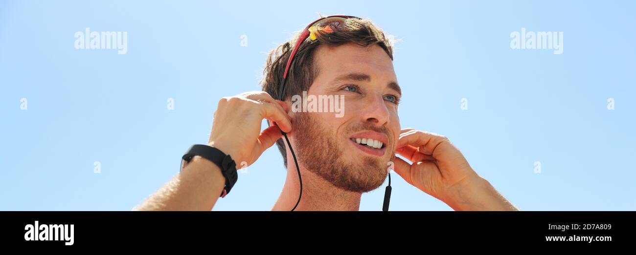 Un giovane uomo che indossa auricolari Bluetooth wireless con tecnologia indossabile. Persona felice che utilizza nuove cuffie, Foto Stock
