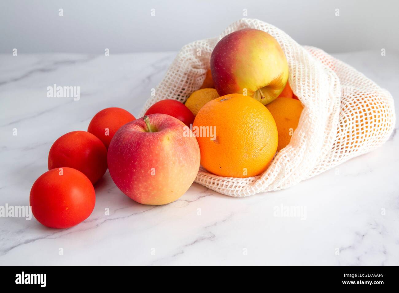Frutta e verdura diverse su un tavolo bianco, all'interno di un sacchetto di stoffa. Concetto di shopping sostenibile e di acquisto senza plastica. Copia spazio Foto Stock