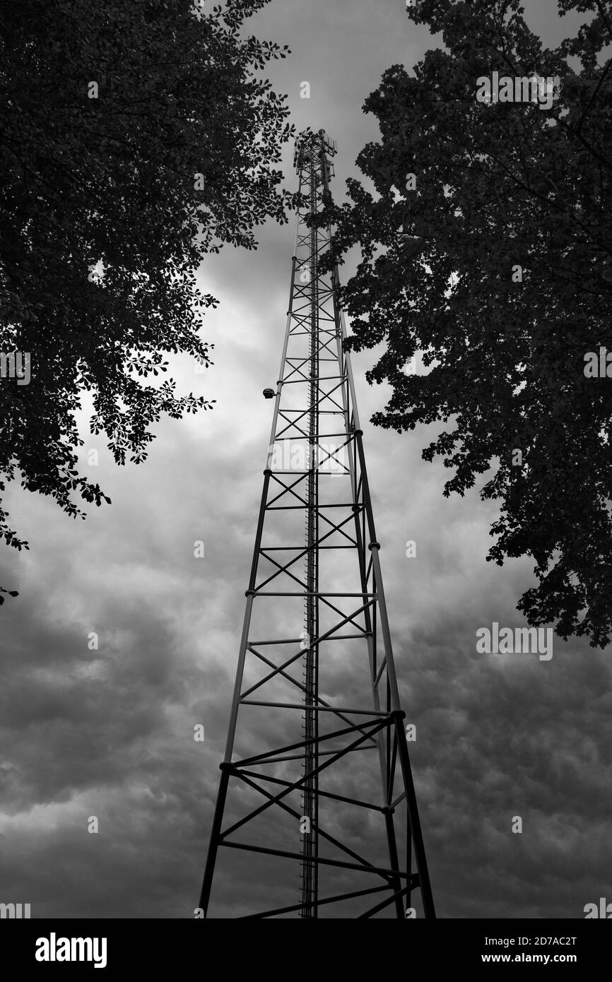 Torre di telecomunicazione con antenna di rete cellulare 5G su sfondo nuvoloso Foto Stock