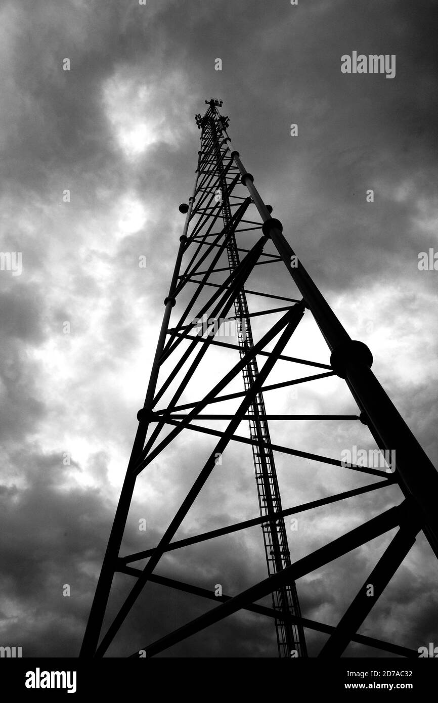 Torre di telecomunicazione con antenna di rete cellulare 5G su sfondo nuvoloso Foto Stock