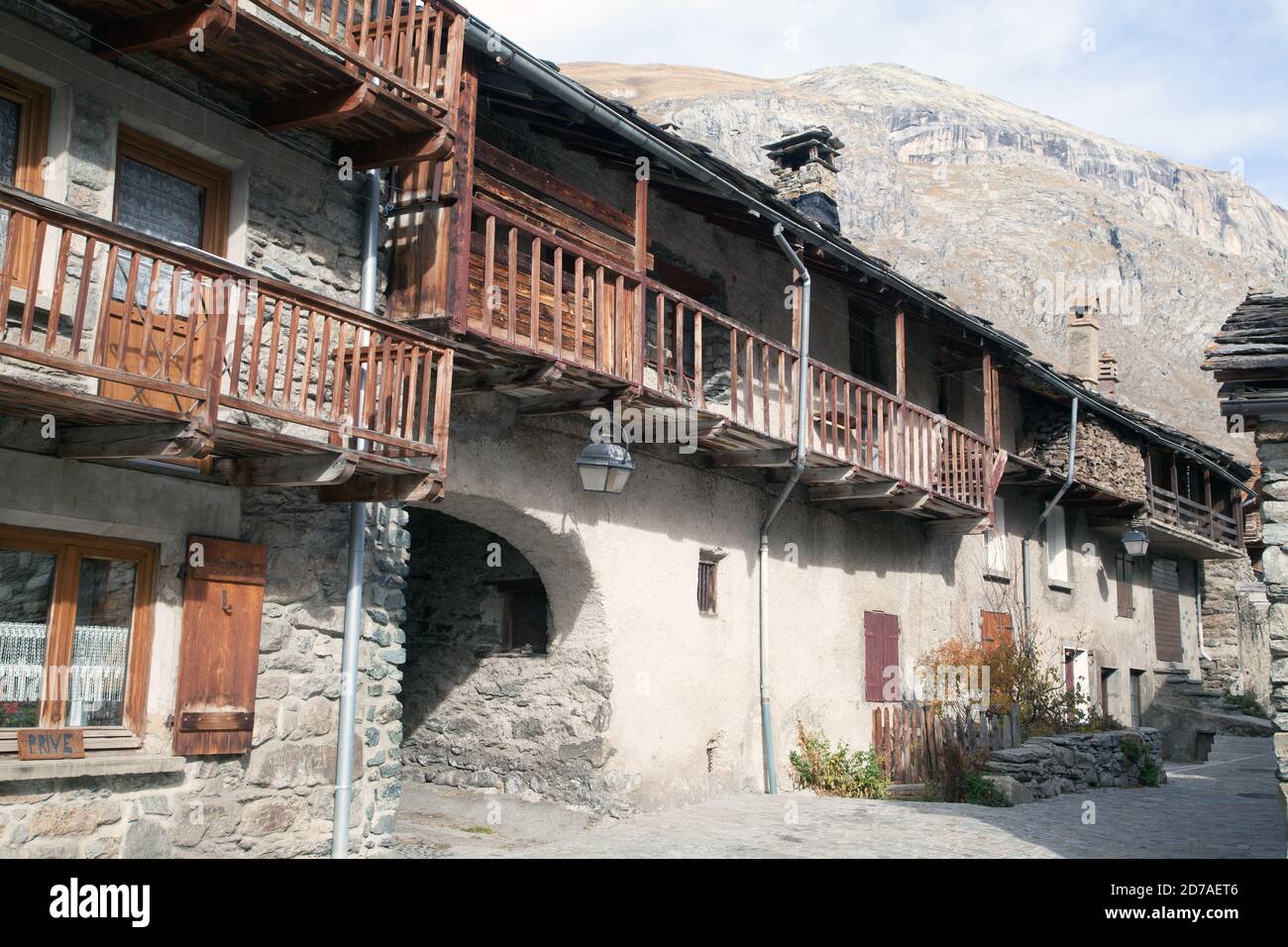 Vecchie case tradizionali in pietra con balconi e moutain sullo sfondo A Bonneval-sur-Arc Haute-Maurienne Savoie Rhône-Alpes Francia Foto Stock