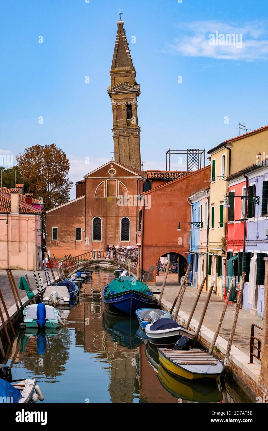 La Torre Pendente della Chiesa di San Martino Vescovo, con luminose e colorate Case Veneziane lungo il canale dell'Isola di Burano - Venezia, Veneto, Italia - Sceni Foto Stock