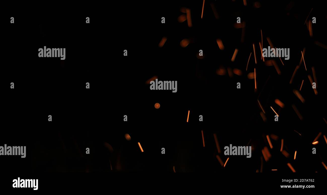 Sfondo di scintille arancio sfumate dal fuoco contro il nero con copyspace Foto Stock