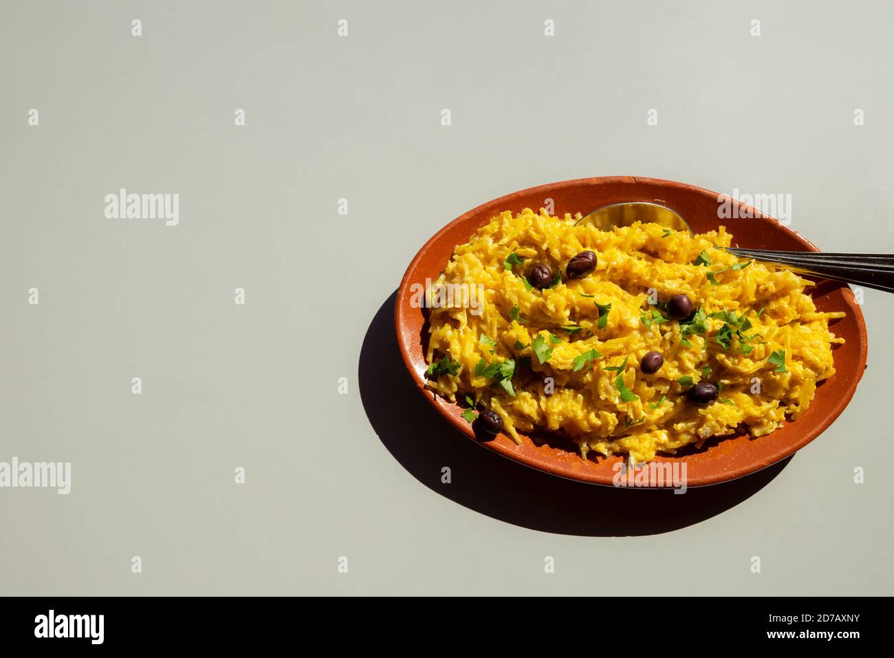 Piatto tradizionale portoghese Bacalhau a Bras o Bacalhau Dourado, una ricetta di merluzzo grattugiato con uova strapazzate e patate fritte. Con spazio per la copia. Foto Stock