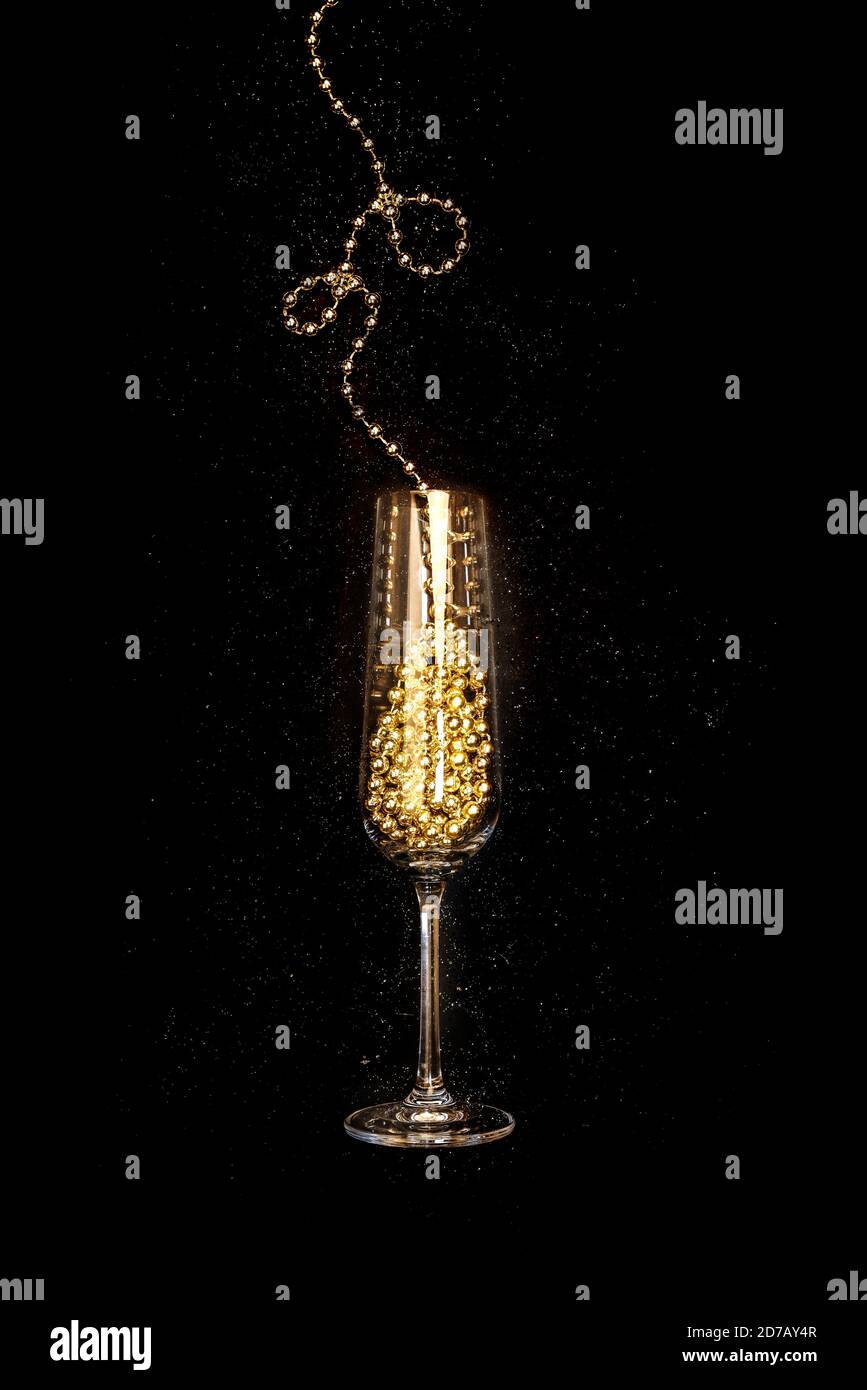 Bicchiere di champagne oro su sfondo nero, festa di Natale e Capodanno Foto Stock