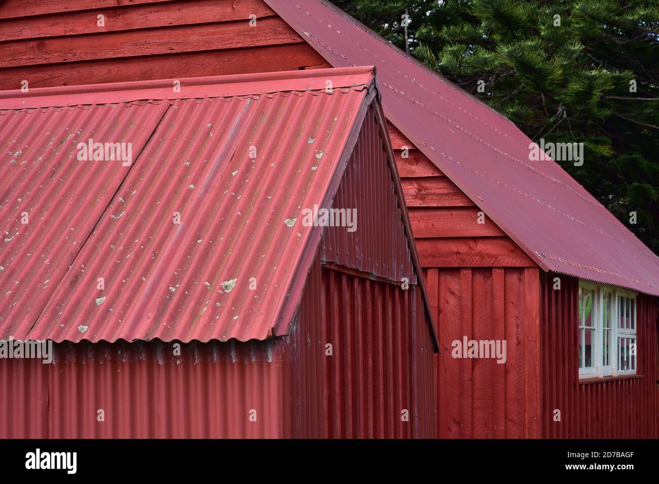 Dettaglio di capannoni vintage dipinti di rosso realizzati in lamiera grecata e ardesia di legno. Foto Stock