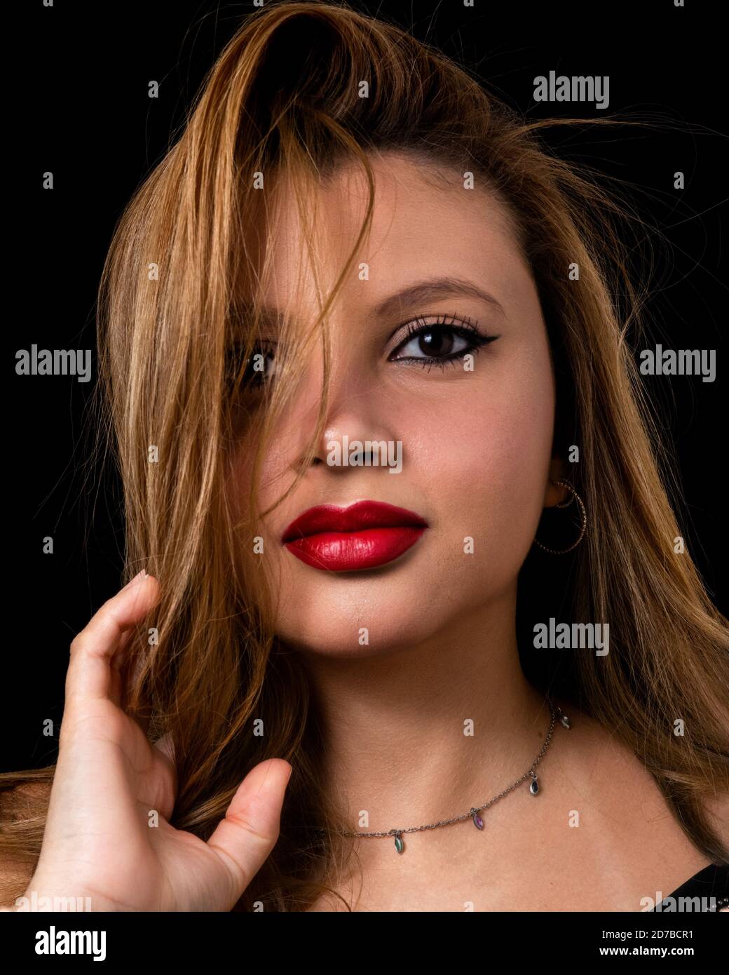 Giovane donna beauty studio ritratto con rossetto rosso isolato uno sfondo nero Foto Stock