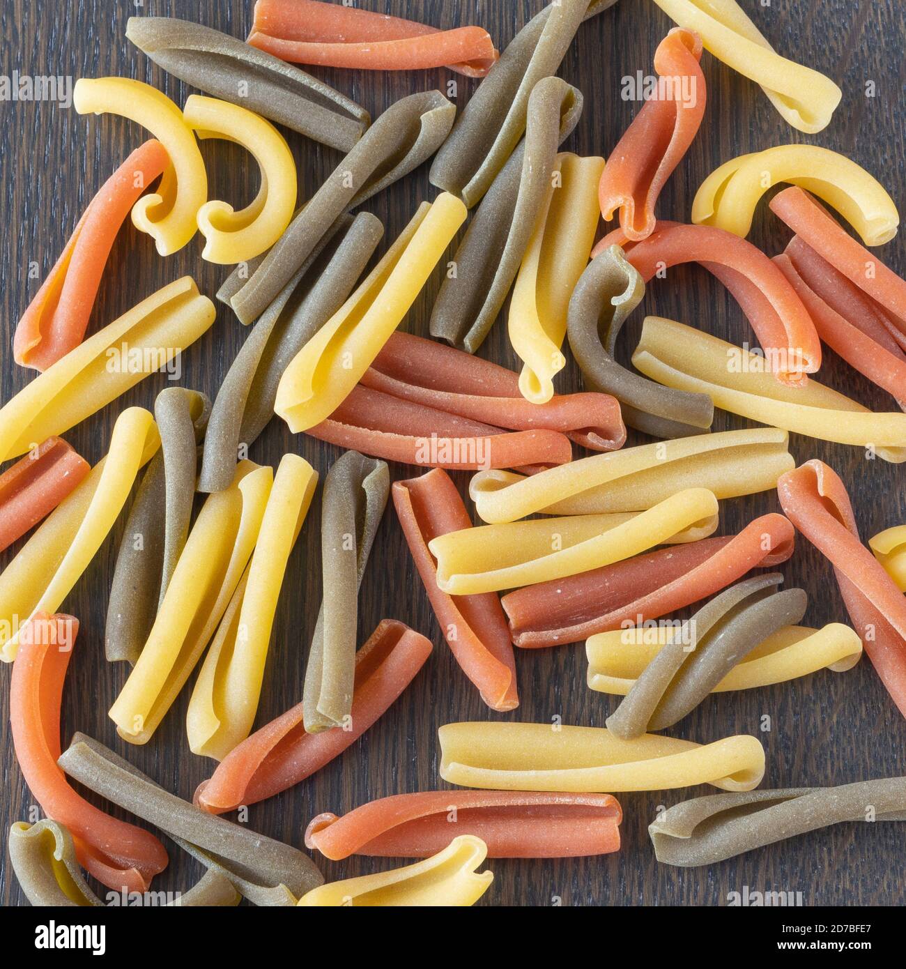 Pasta tricolore, macaron italiano in tre colori chiamato Caserecce su fondo neutro Foto Stock