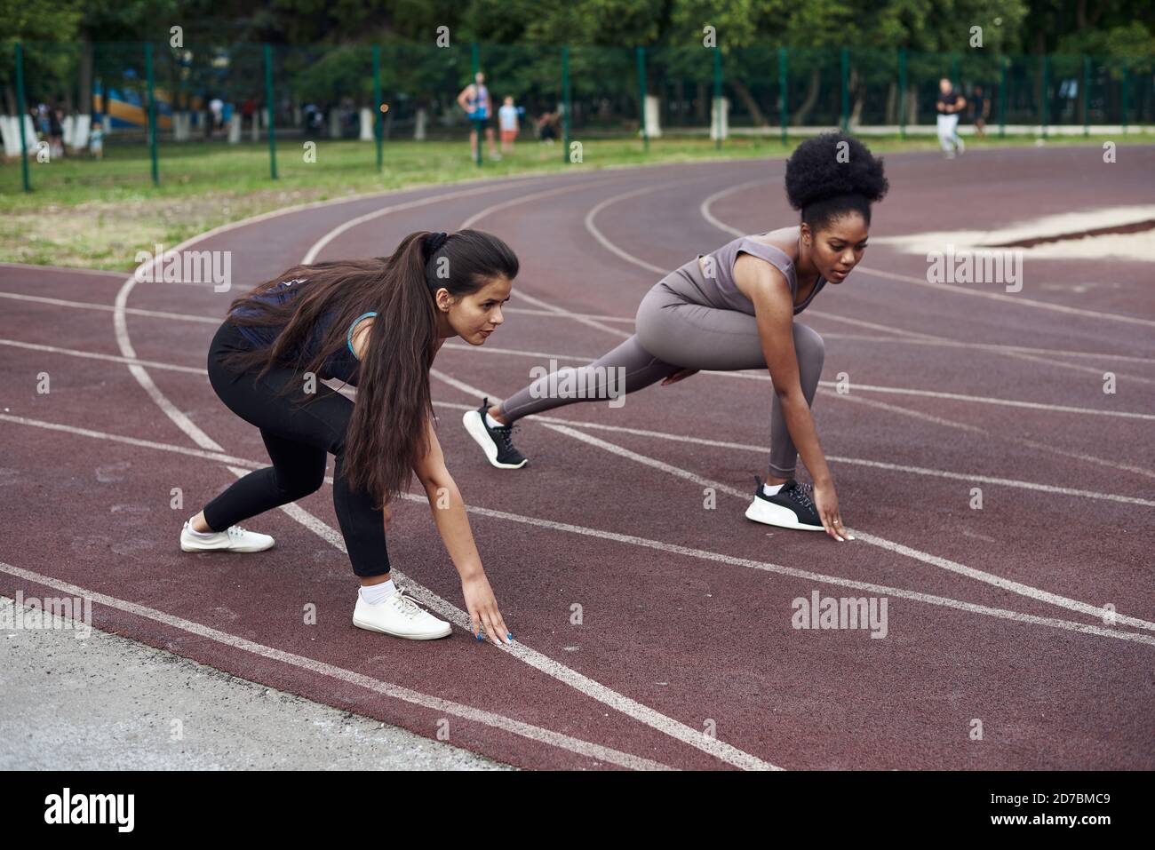 Chi è più veloce. Concetto di leadership e primato. Due giovani donne gareggano nello stadio aperto. Foto Stock