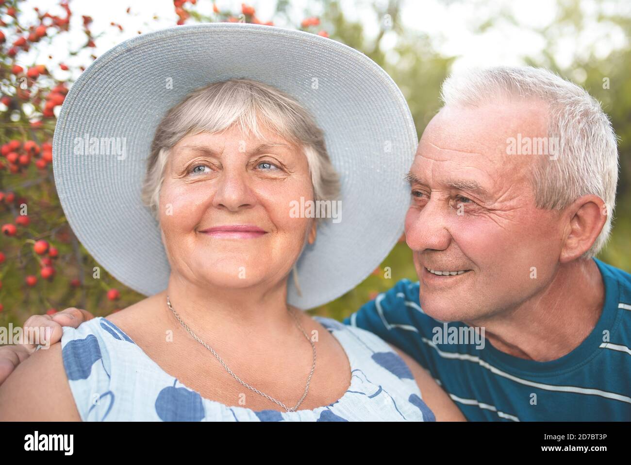Autentico scatto all'aperto di coppie anziane che si divertono in giardino e benedetti con amore. Concetto di amore Foto Stock