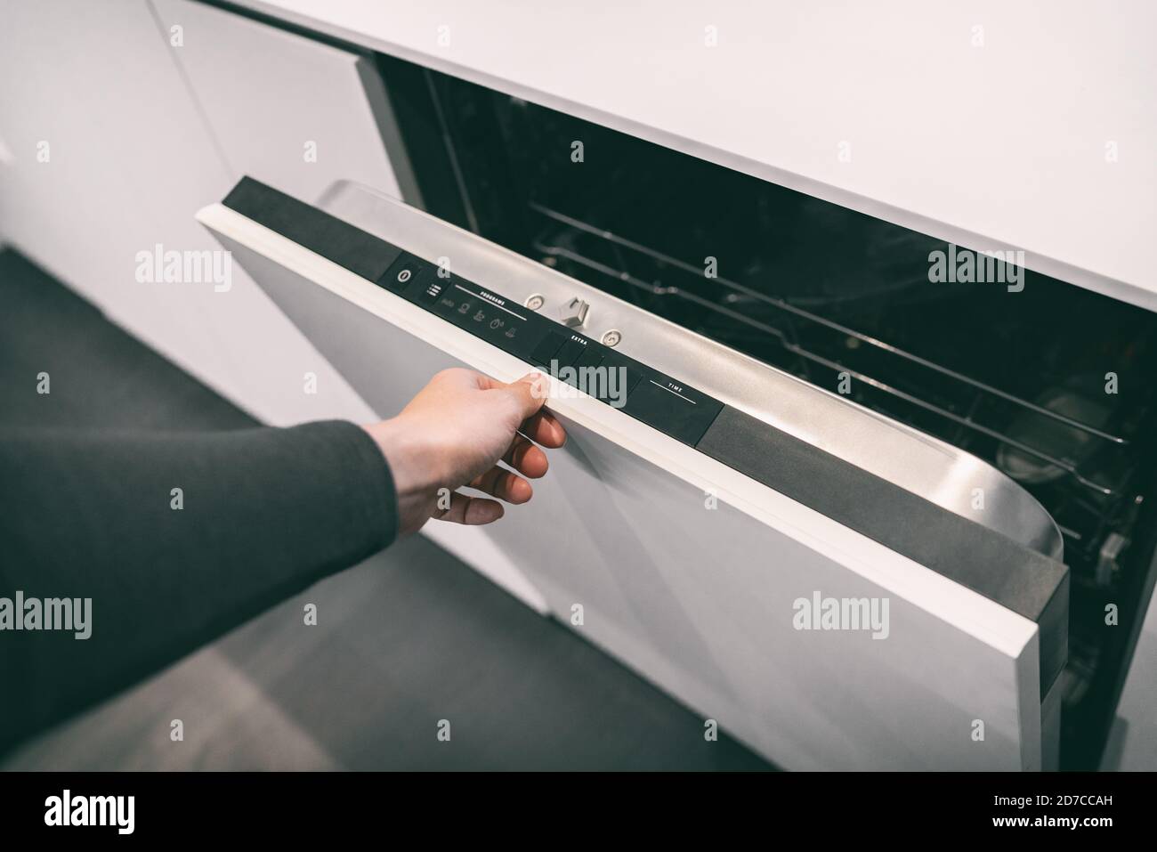 Donna apertura pannello personalizzato lavastoviglie da incasso in moderna cucina casa arredamento tendenza. Piatti di lavaggio in casa Foto Stock