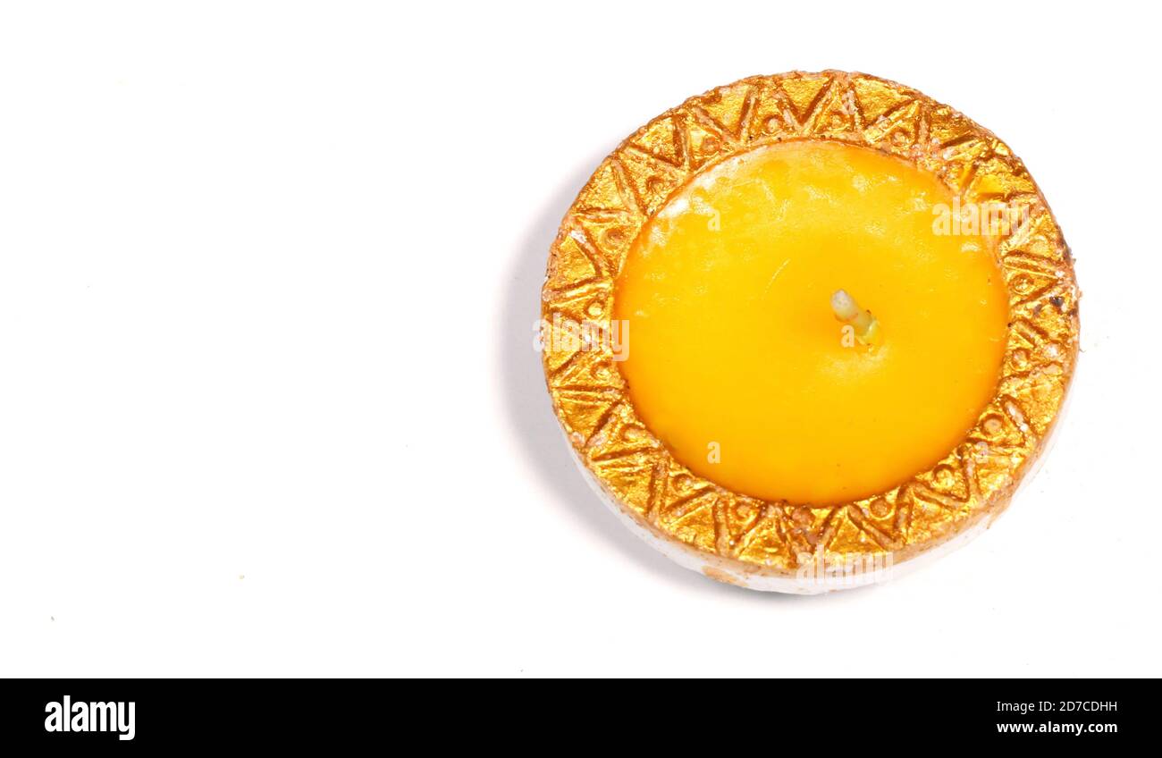 Un primo piano di una candela gialla su sfondo bianco Foto Stock