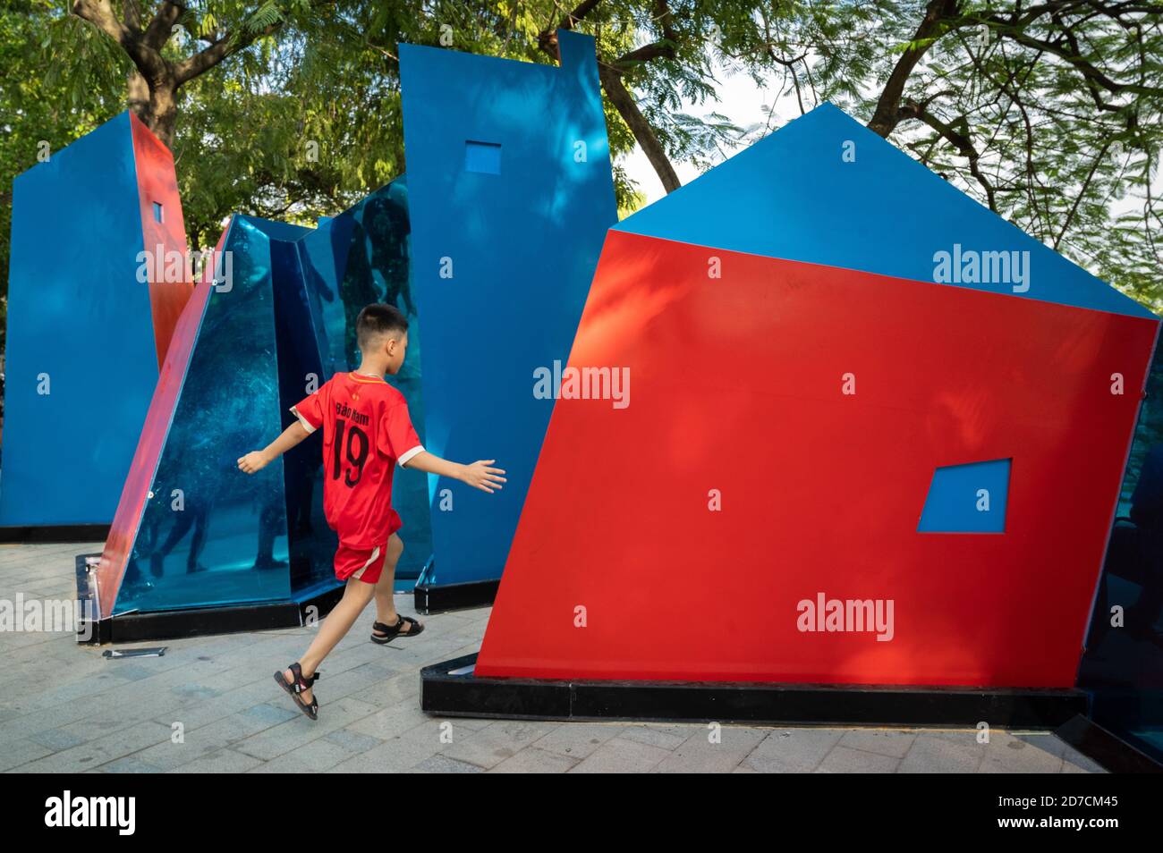 Ragazzo che gioca intorno a strutture cubiste di Hoan Kiem Lago, Hanoi, Vietnam Foto Stock