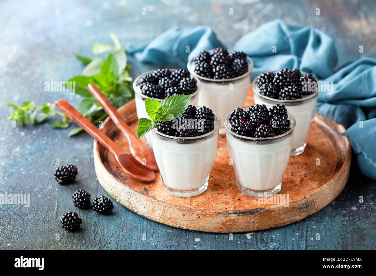 Panna cotta di cocco con bacche nere fresche in vetro, fuoco selettivo Foto Stock