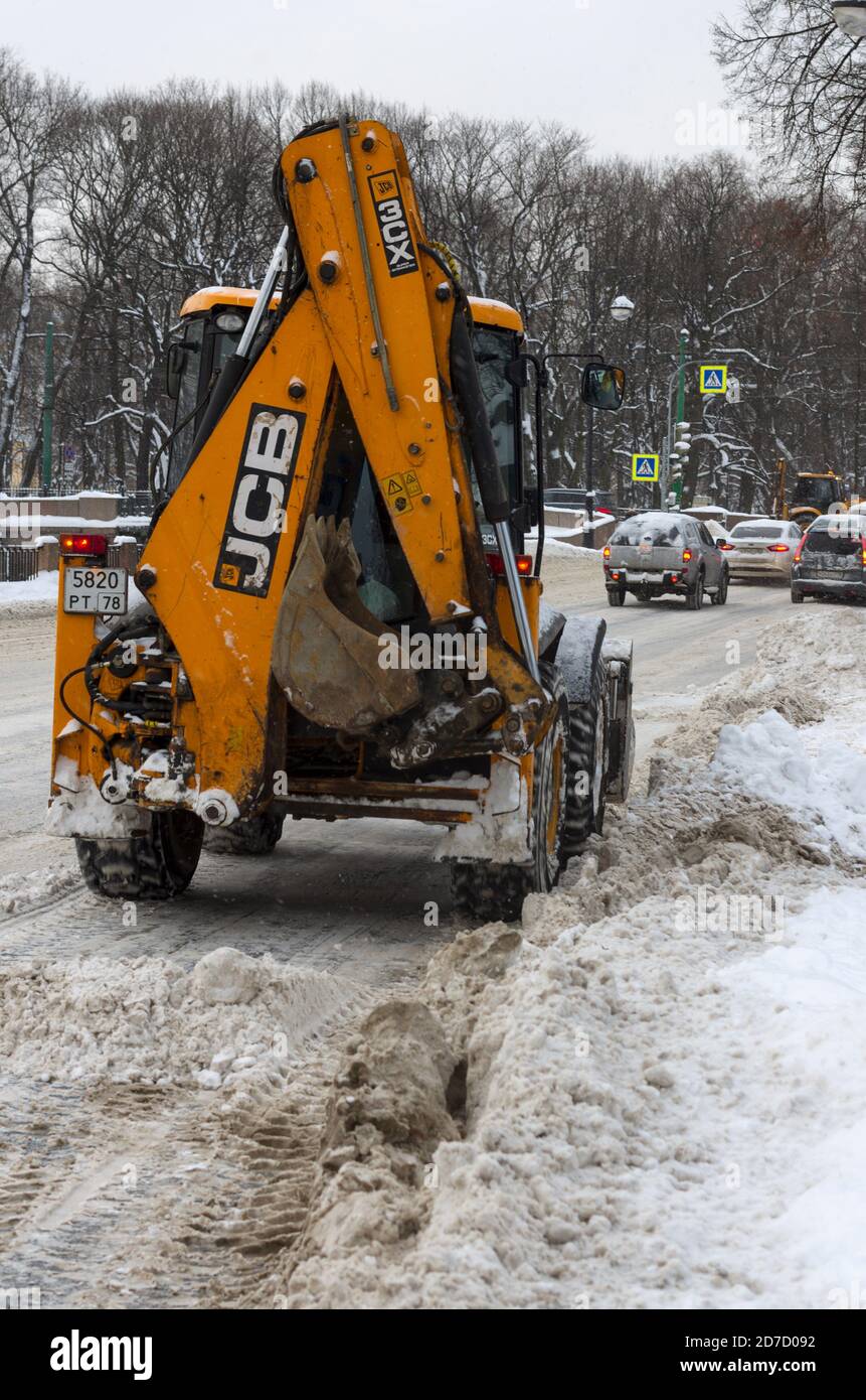 San Pietroburgo, Russia - 06 febbraio 2018: Trattore giallo JCB sgombero della strada dopo una nevicata Foto Stock
